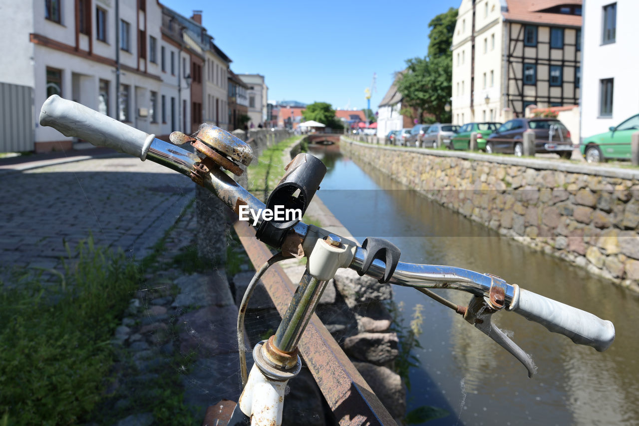 BICYCLE PARKED BY FOUNTAIN IN CITY