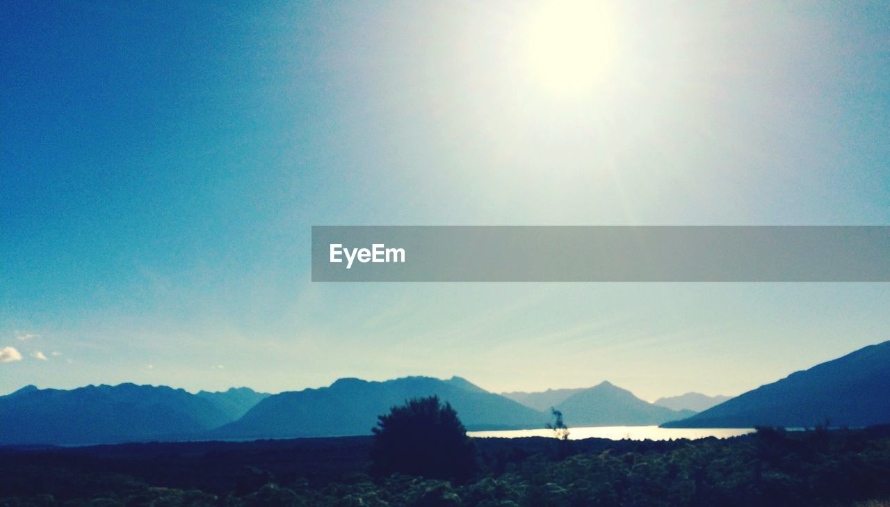 SILHOUETTE MOUNTAINS AGAINST BLUE SKY