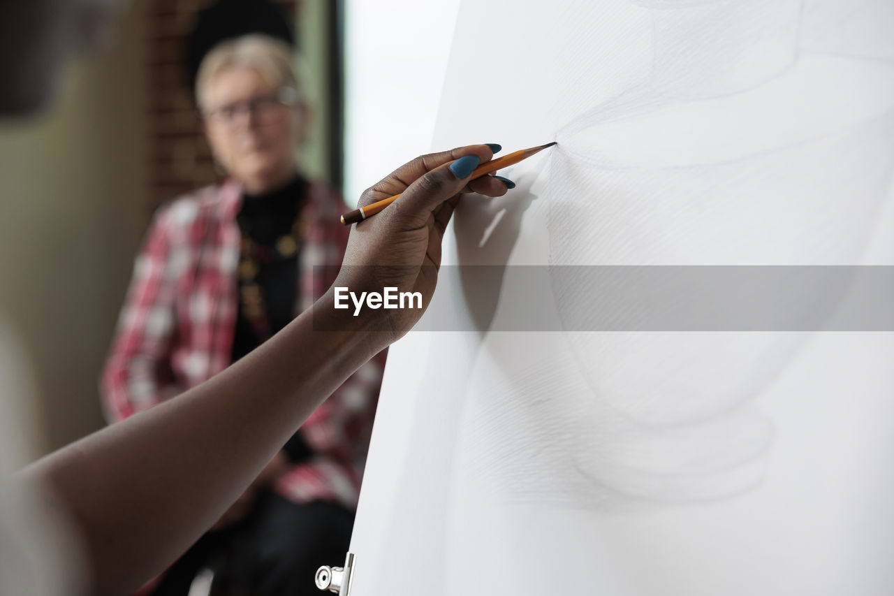 Hand of woman sketching on canvas