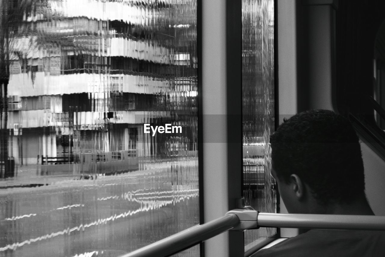 WOMAN LOOKING THROUGH WINDOW