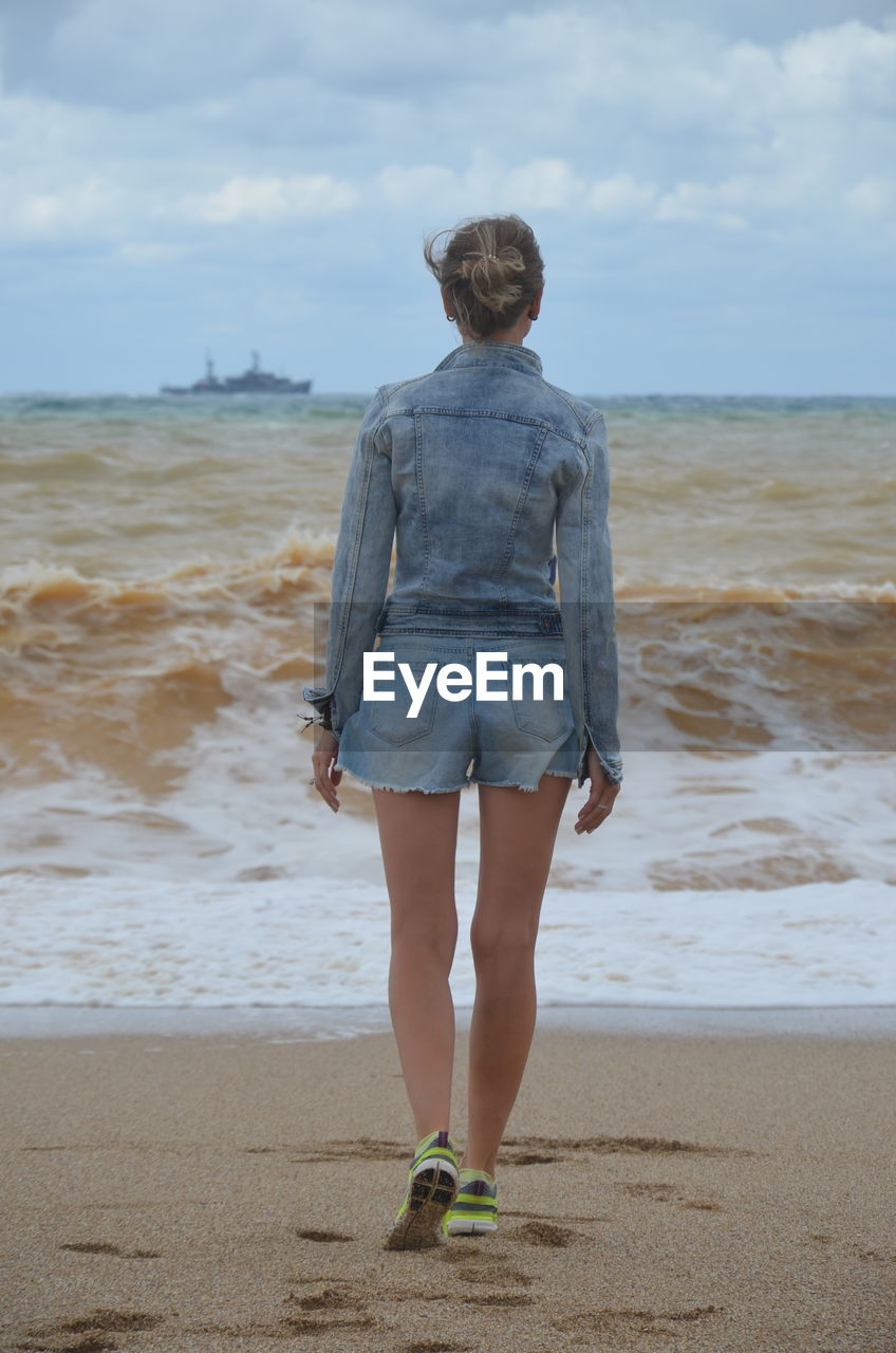 Rear view of woman standing on beach