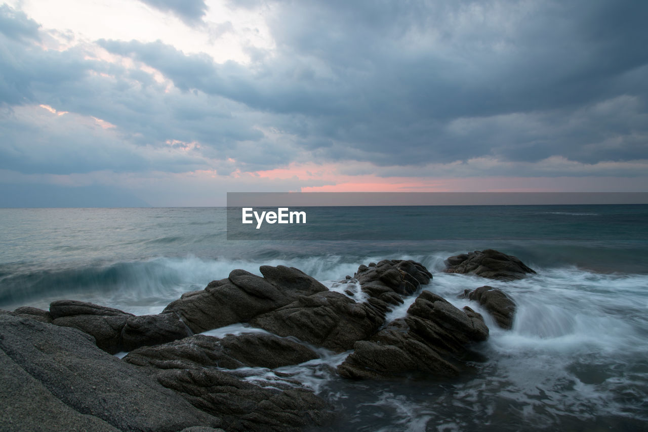 Scenic view of rocks on beach against sky