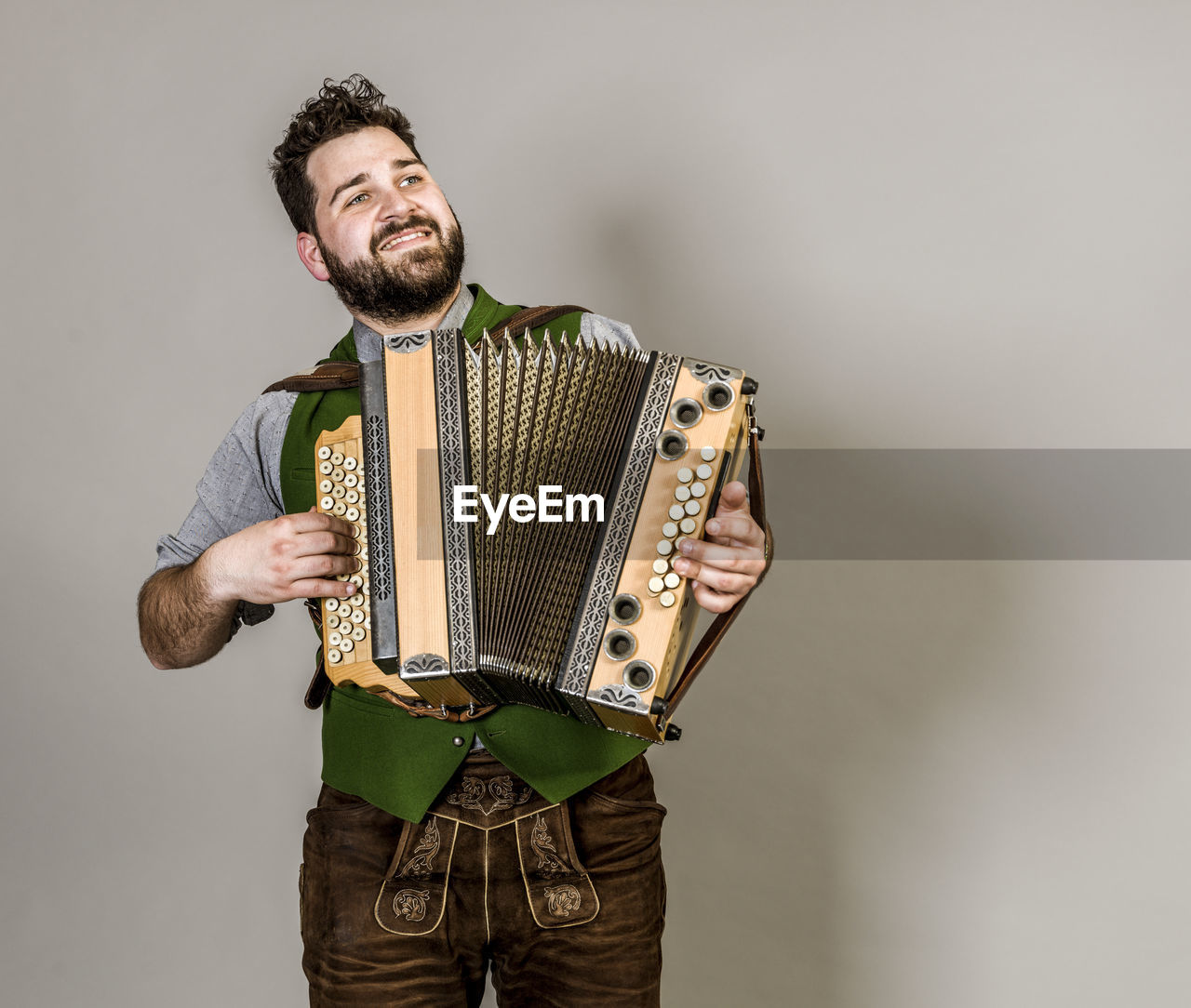 FULL LENGTH OF YOUNG MAN PLAYING GUITAR AGAINST WHITE BACKGROUND