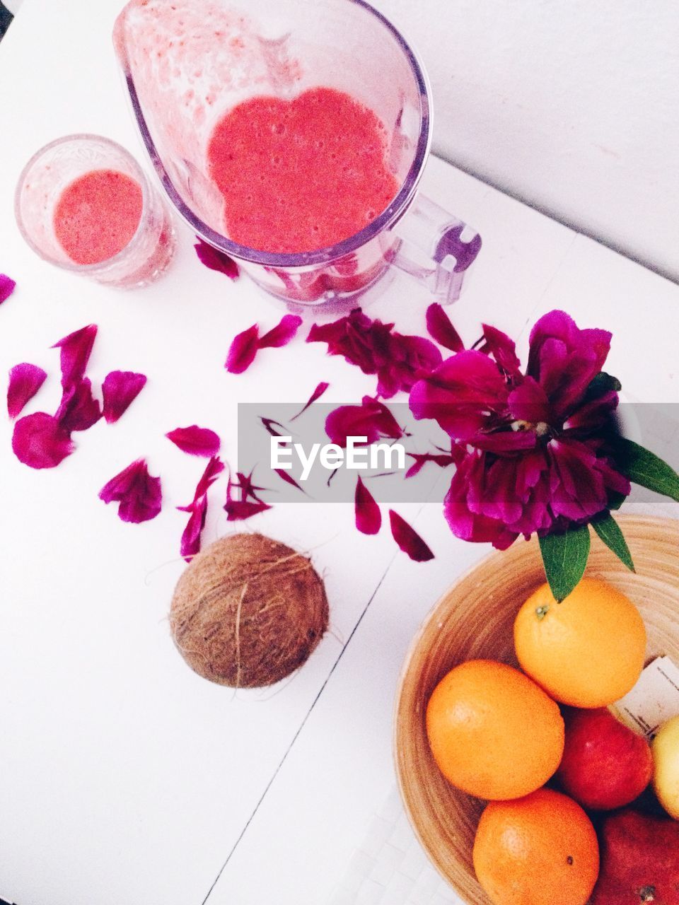 Smoothie in blender surrounded by flower petals