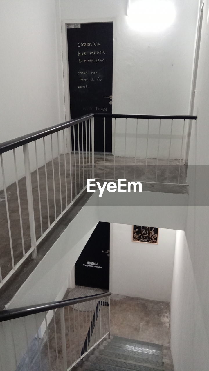 HIGH ANGLE VIEW OF ILLUMINATED TEXT ON STAIRCASE IN BUILDING
