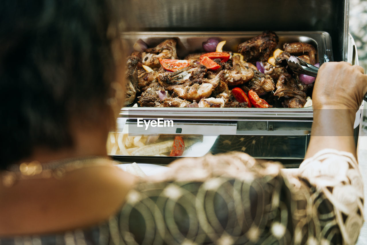 Midsection of woman on a meat buffet 