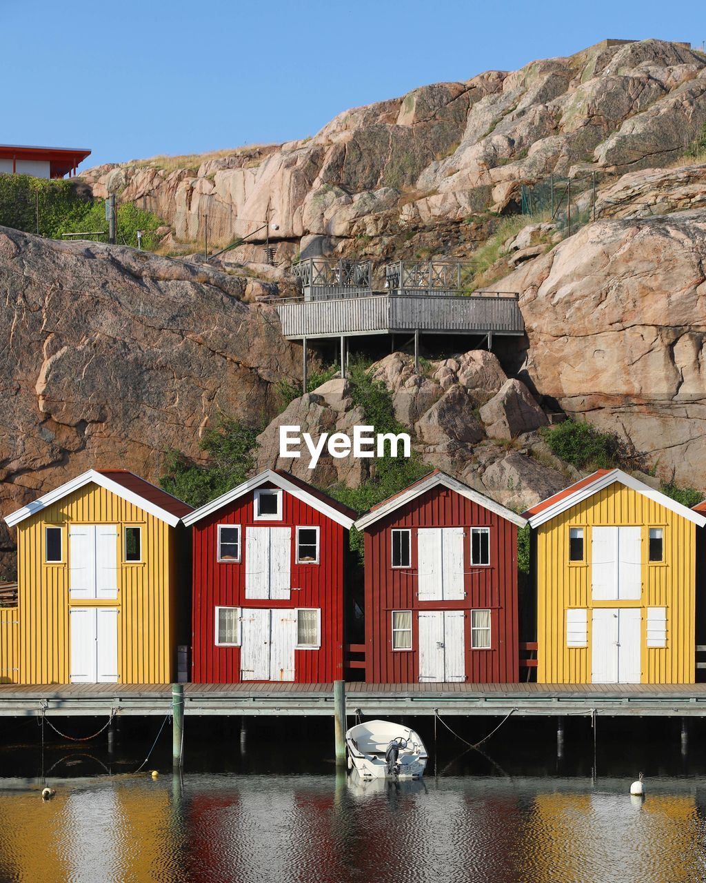 HOUSES BY RIVER AGAINST MOUNTAINS