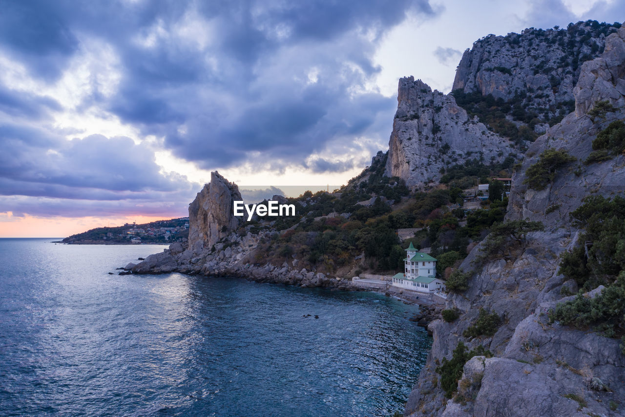 ROCK FORMATIONS IN SEA AGAINST SKY