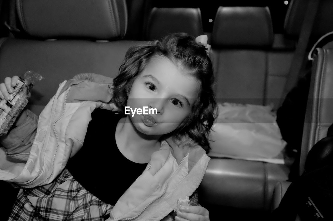 Portrait of cute girl sitting in car