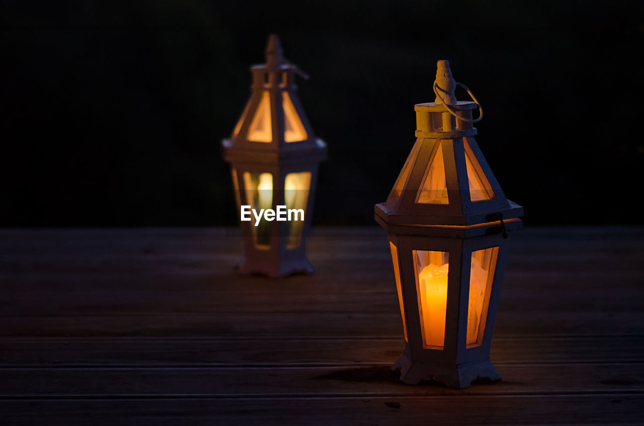 Close-up of illuminated lamps on floorboard during night