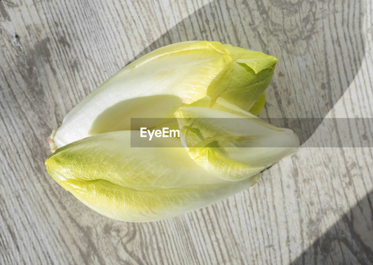 food and drink, yellow, food, healthy eating, plant, wellbeing, wood, produce, freshness, slice, fruit, no people, table, petal, close-up, indoors, still life, flower, citrus fruit, directly above, cross section, high angle view, leaf, vegetable, nature, lemon, citrus, sunlight