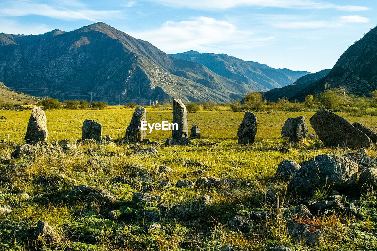 SCENIC VIEW OF FIELD AGAINST MOUNTAIN RANGE