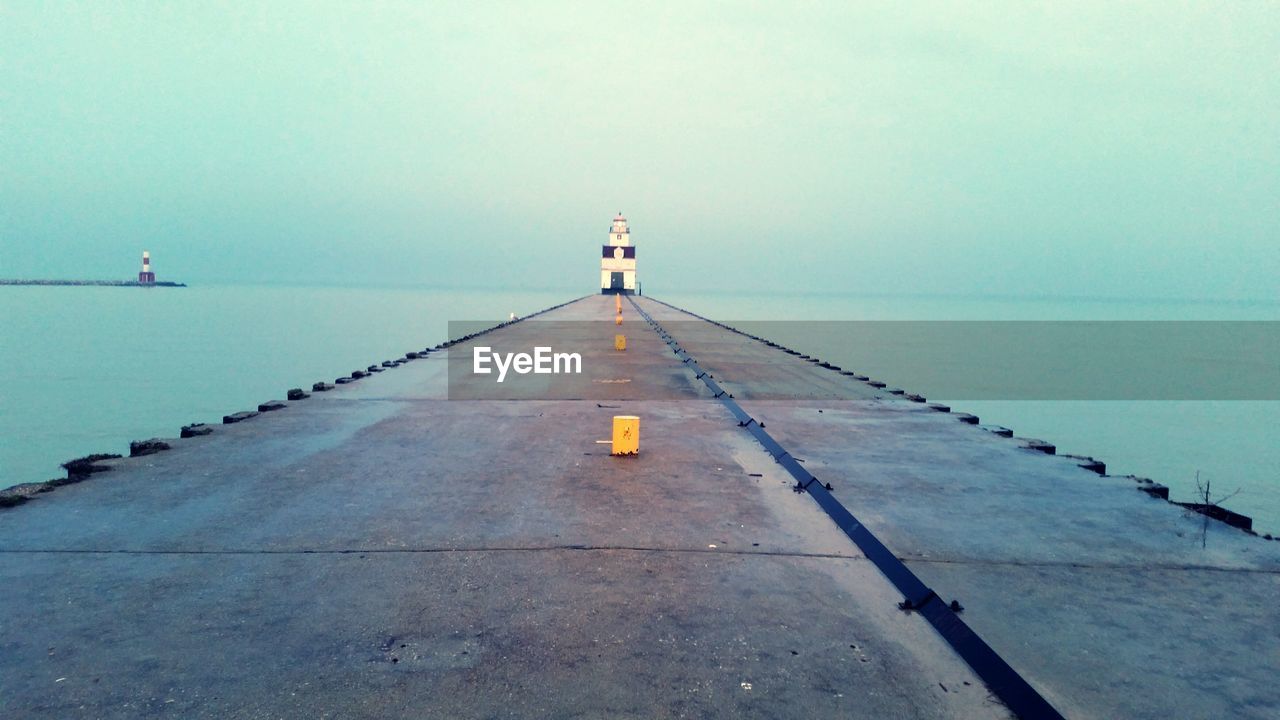 Empty road along calm blue sea