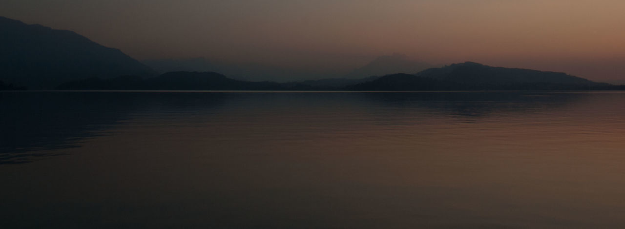 Panoramic shot of calm lake against sky at sunset