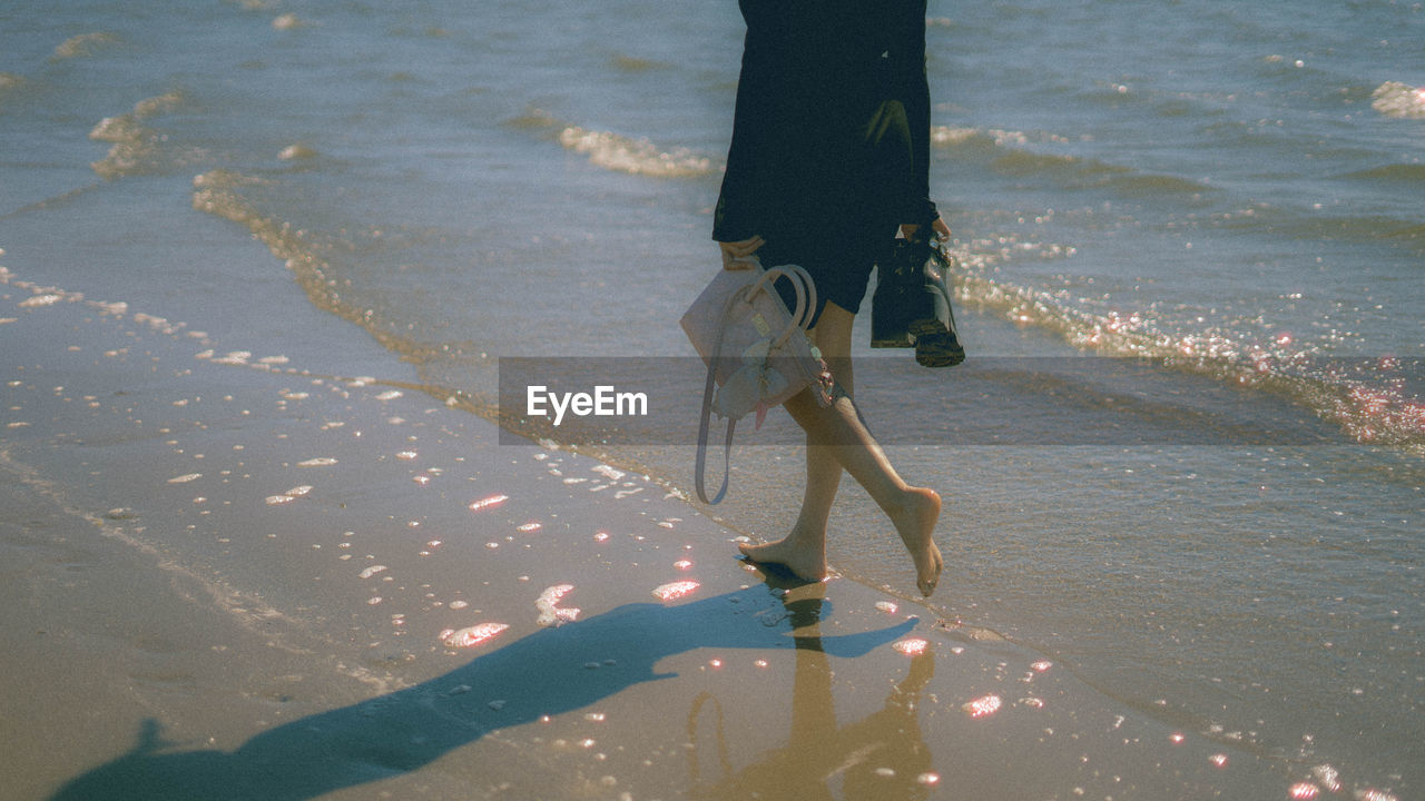 Low section of person walking on beach