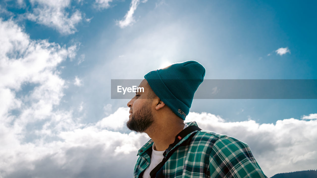 low angle view of young man standing against sky