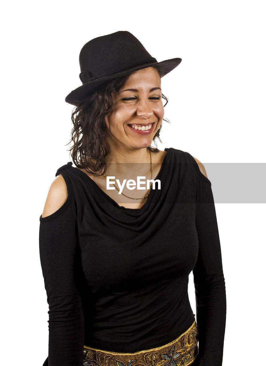 Smiling woman wearing hat while standing against white background