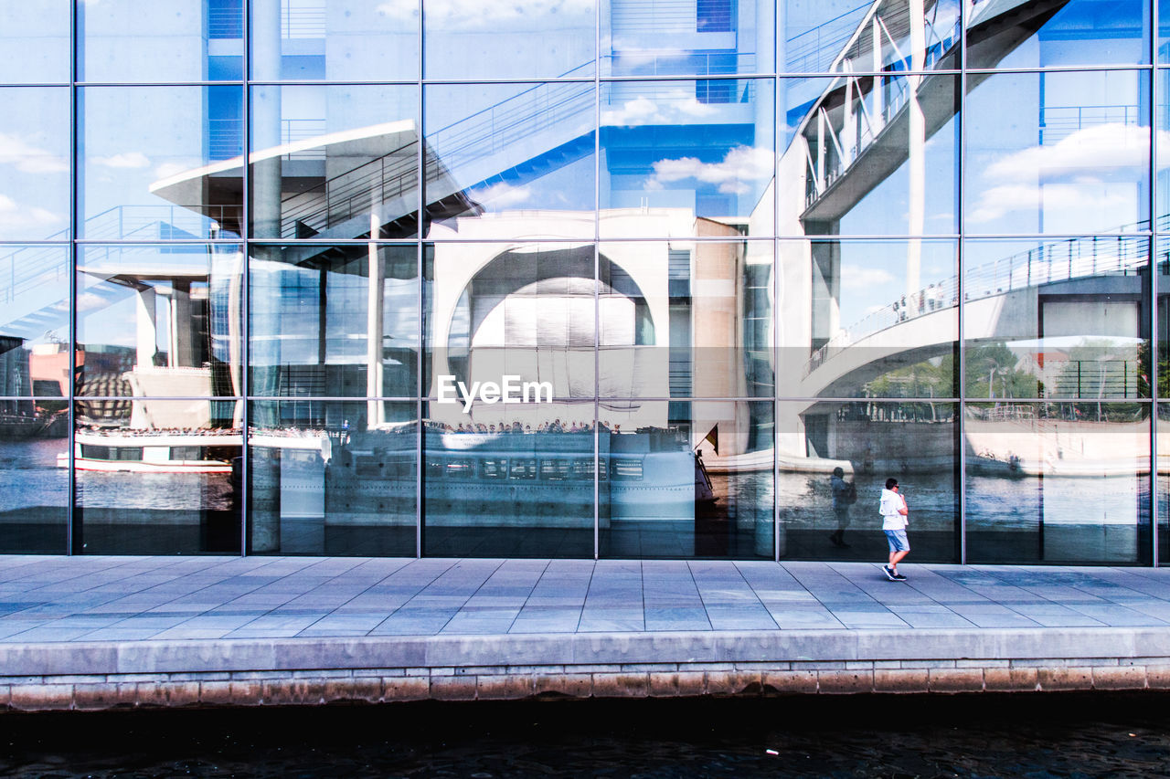 Reflection of bridge and canal on glass building