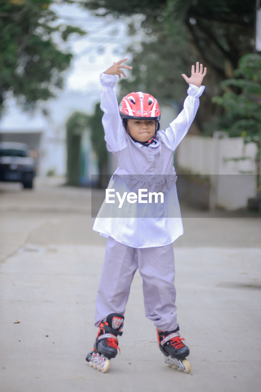 Portrait of boy standing on footpath