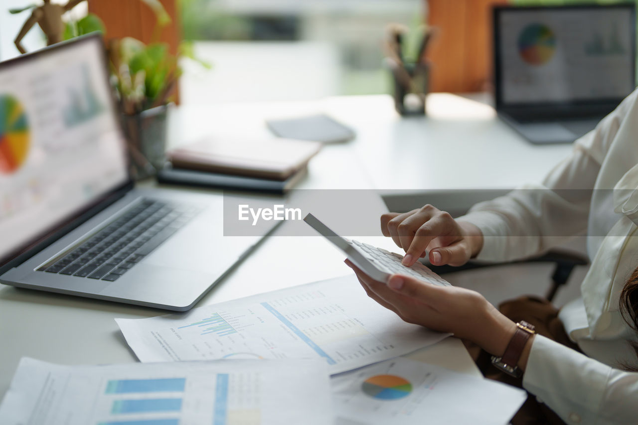 Midsection of business colleagues working on table