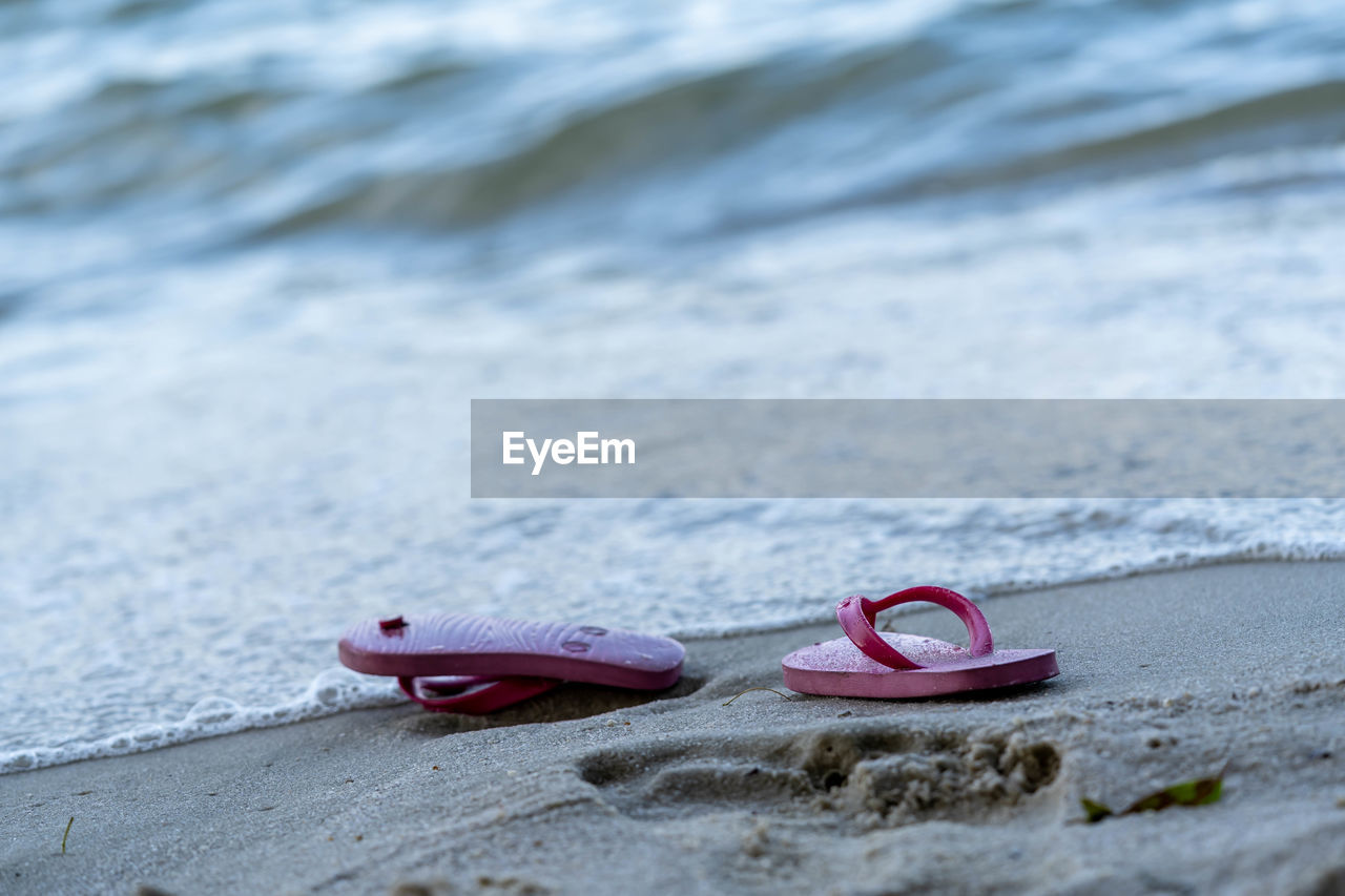 CLOSE-UP OF SHOES ON SHORE