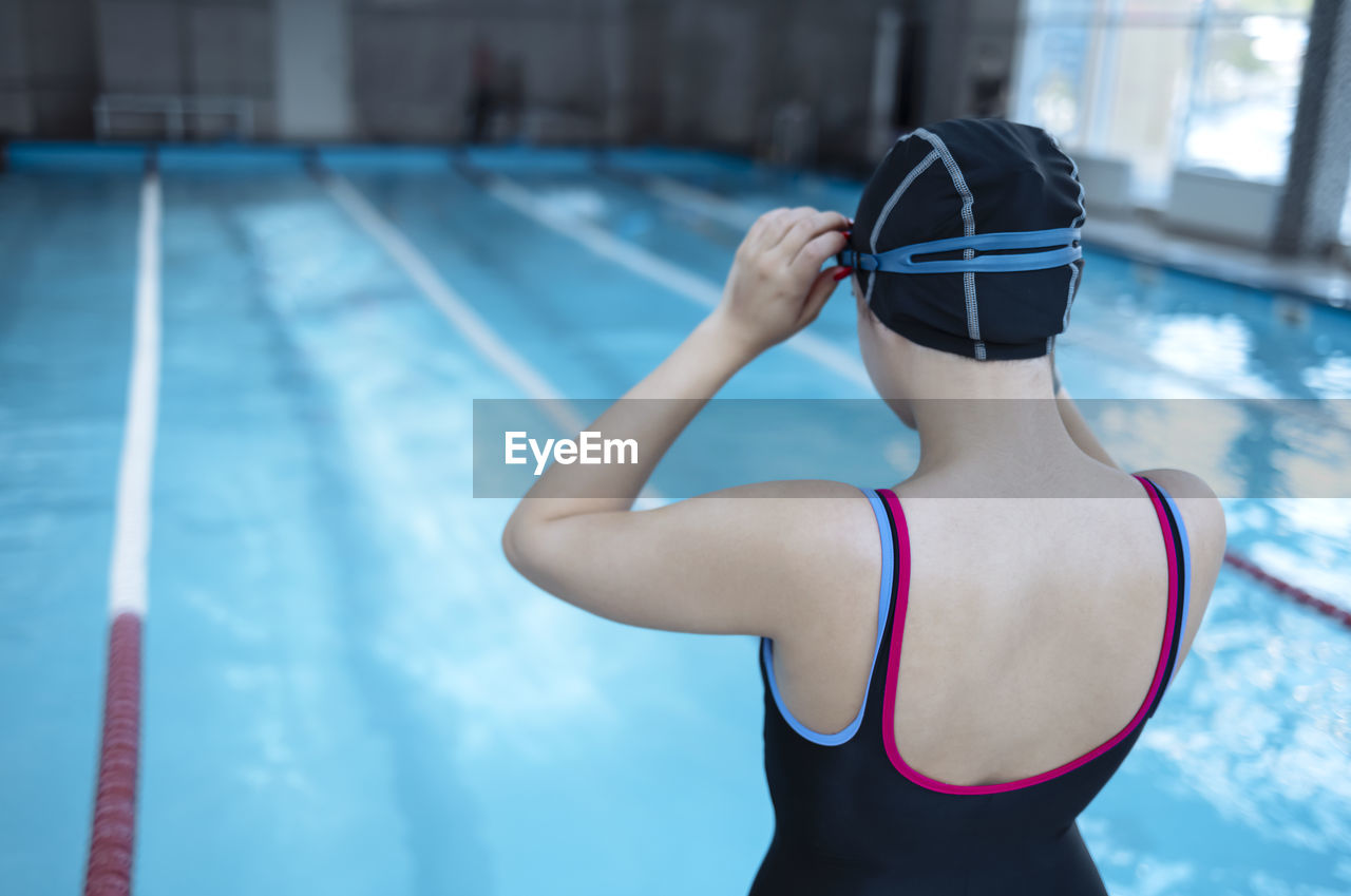 rear view of woman exercising in gym against sky