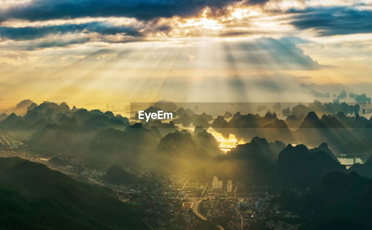 Sunlight streaming through clouds on halong bay during sunrise