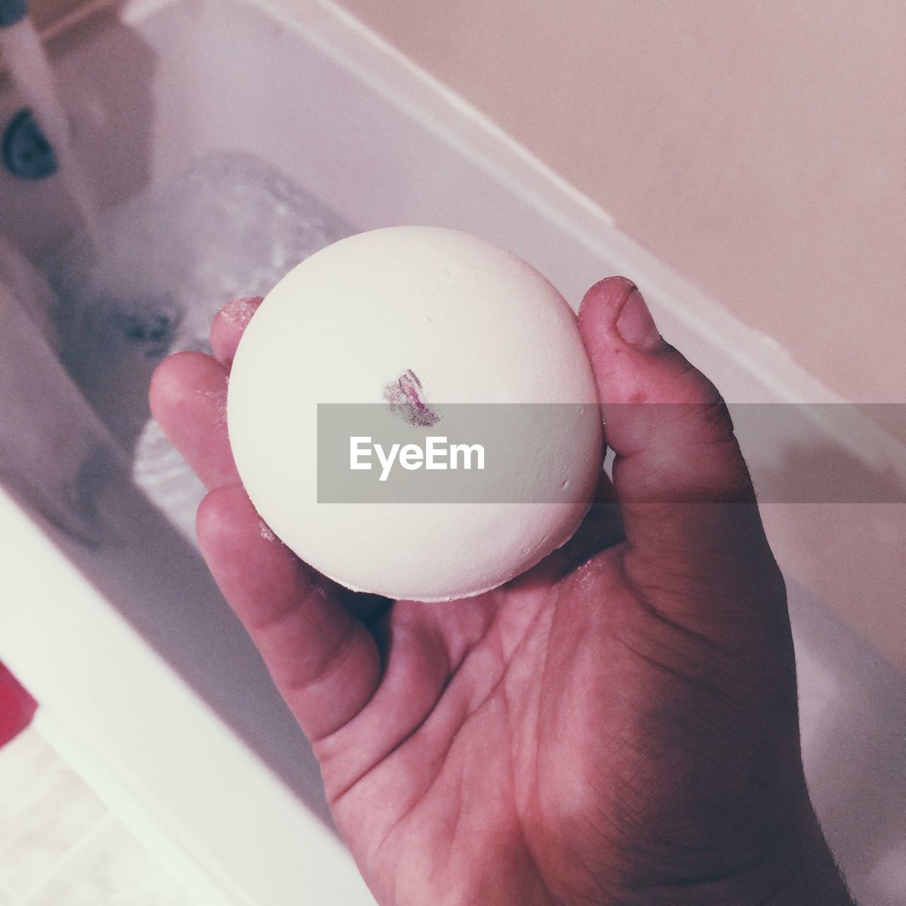 Cropped image of man holding soap in bathroom