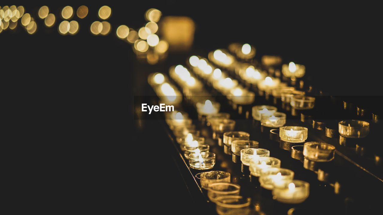 Tea light candles burning on votive stand in church