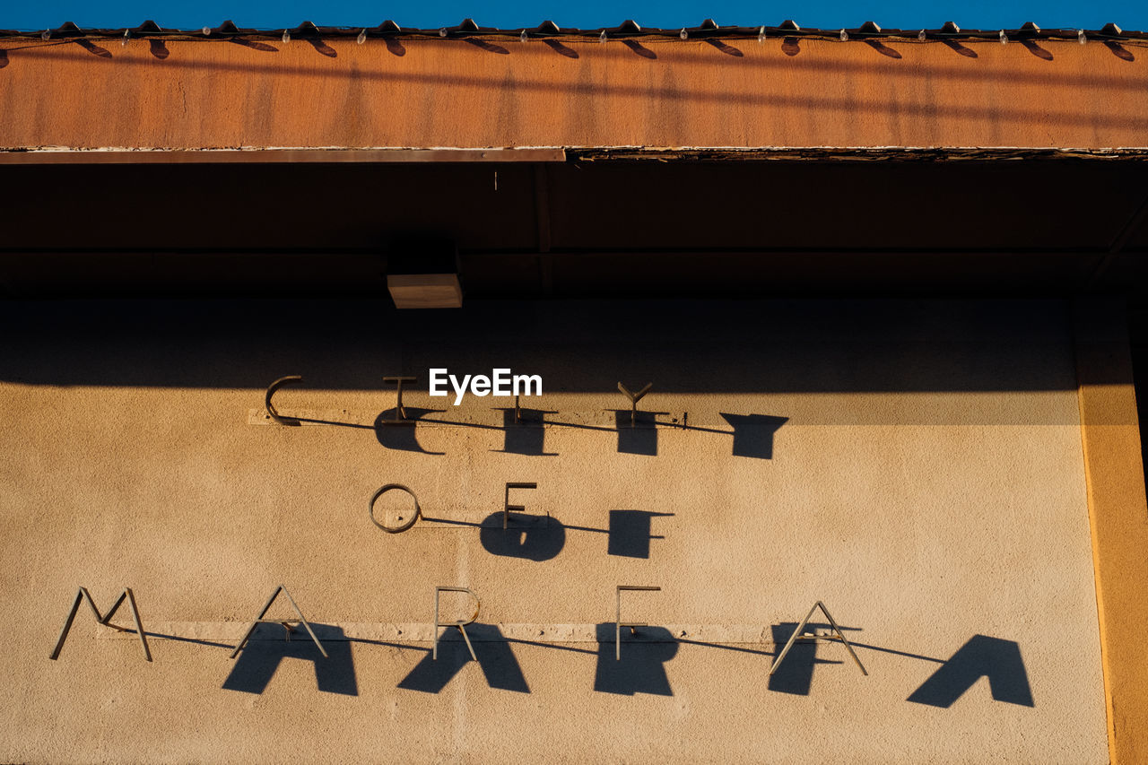 HIGH ANGLE VIEW OF TEXT ON WALL WITH BUILDING