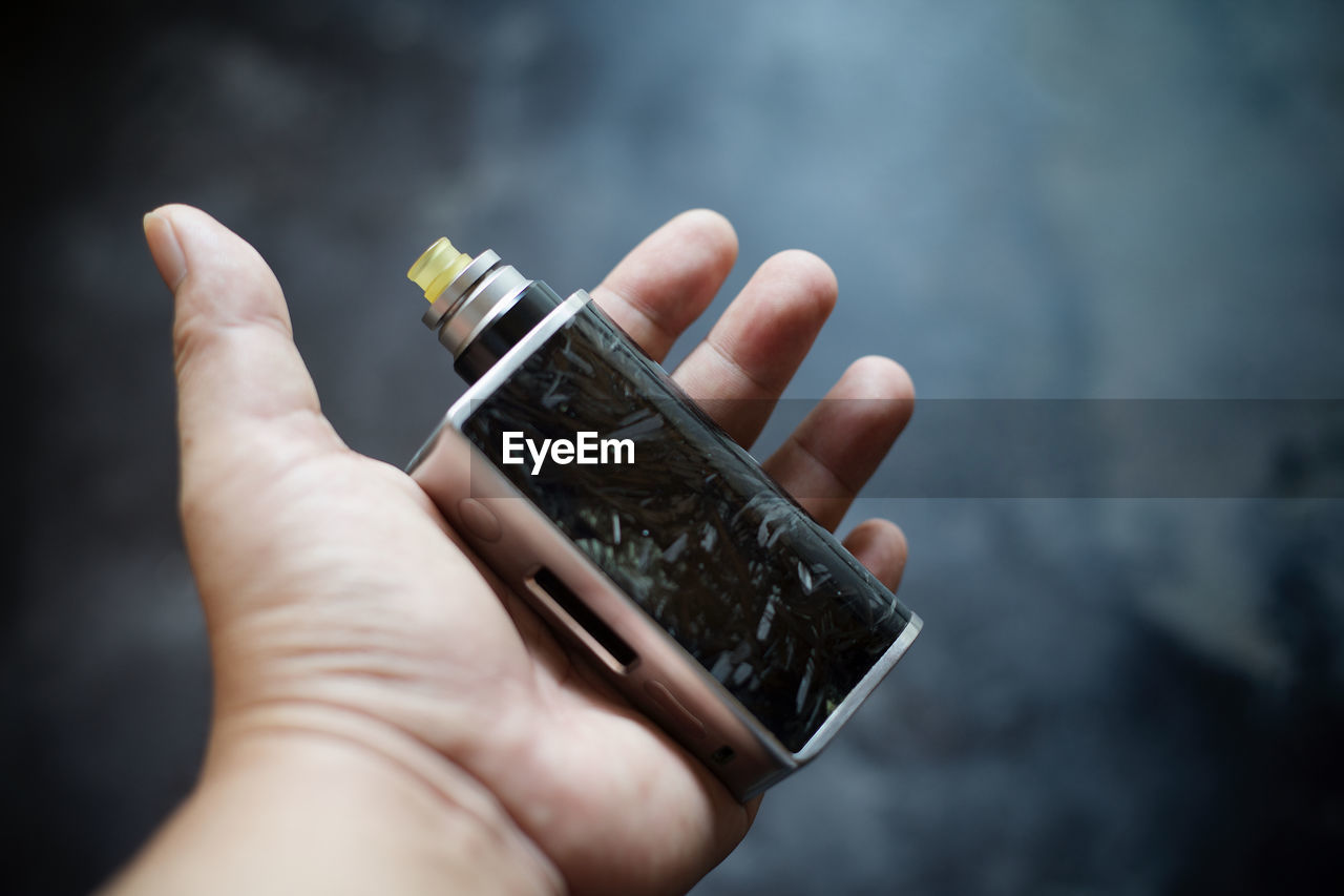 Close-up of cropped hand holding electronic cigarette