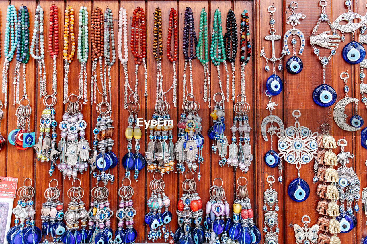Various jewelry hanging on wooden wall at market