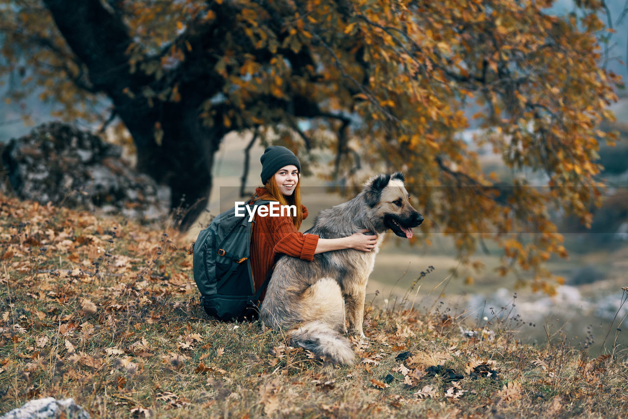 Woman sitting with dog on grass