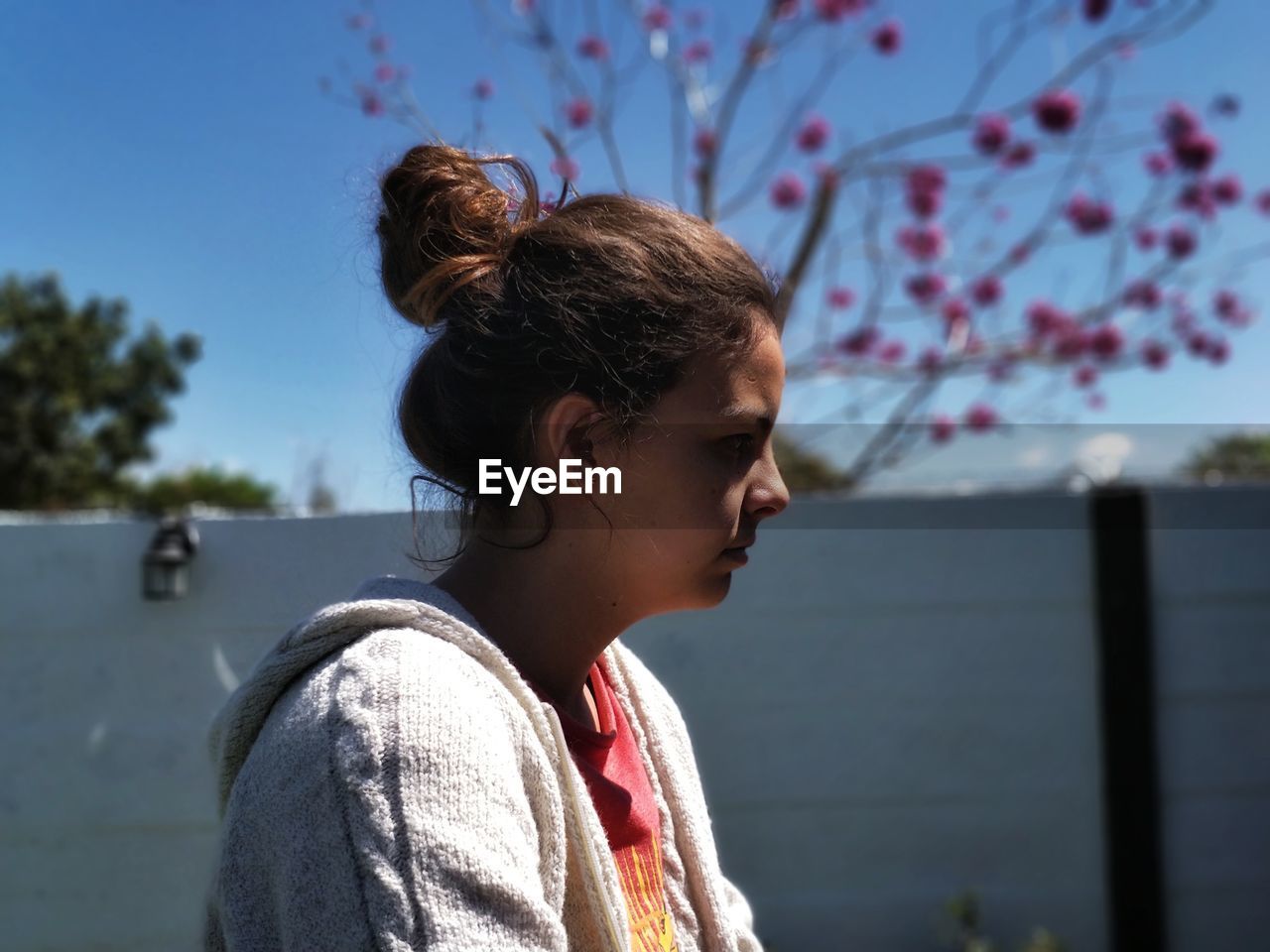 Side view of thoughtful teenage girl looking away against sky