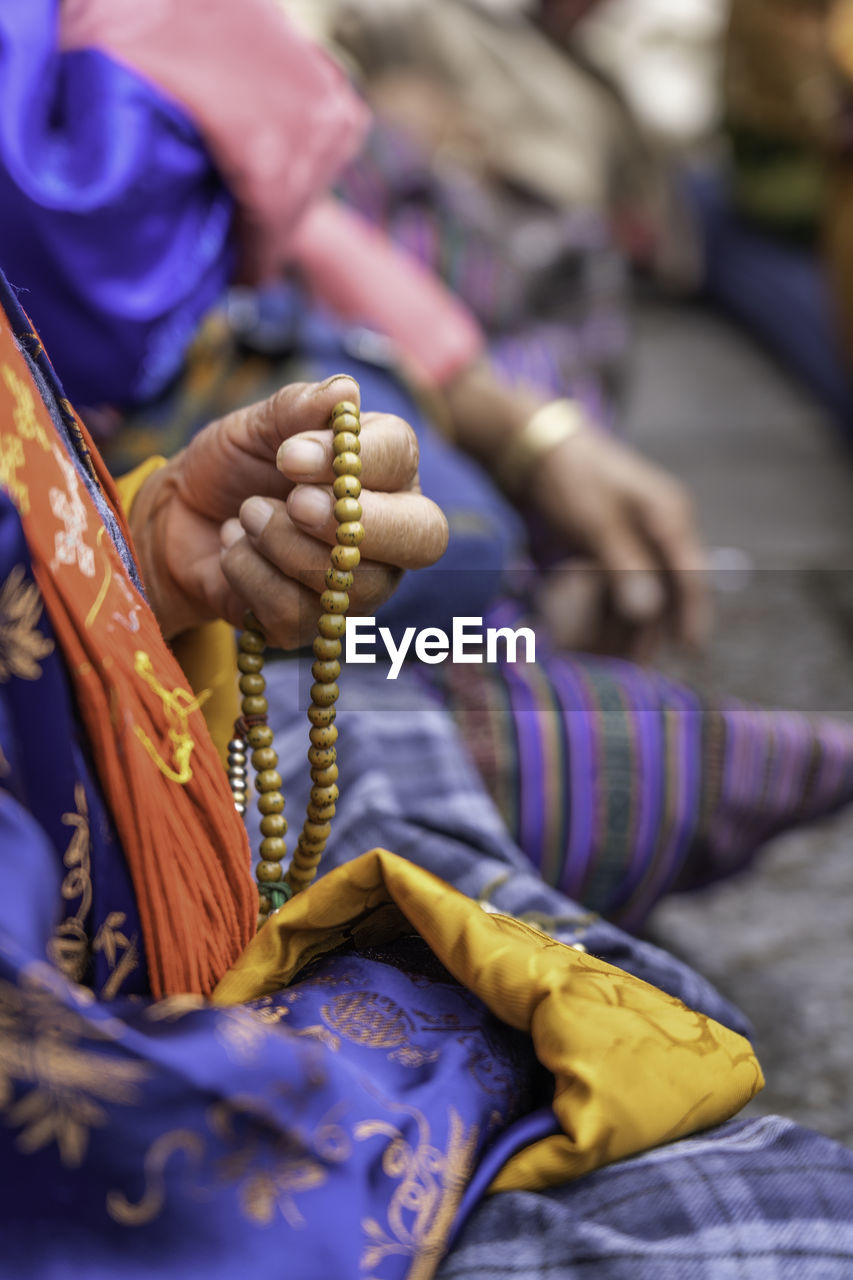 Close-up of hand holding prayer beads