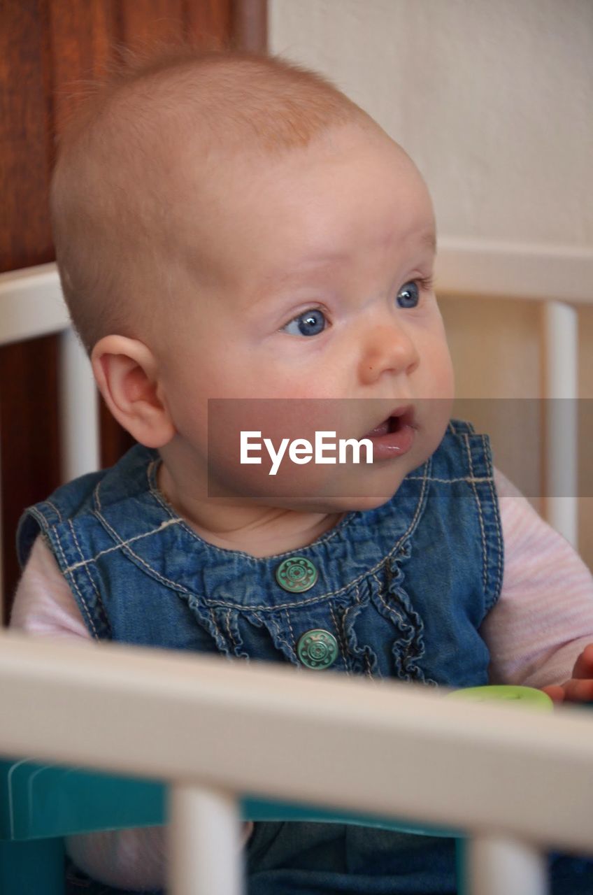 Close-up of baby girl in crib