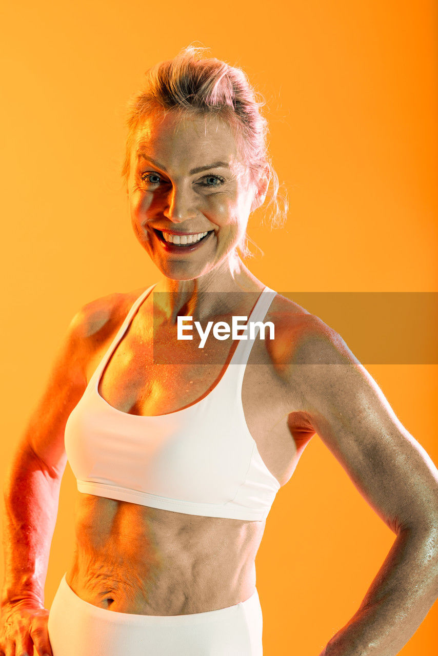 portrait of woman standing against yellow background