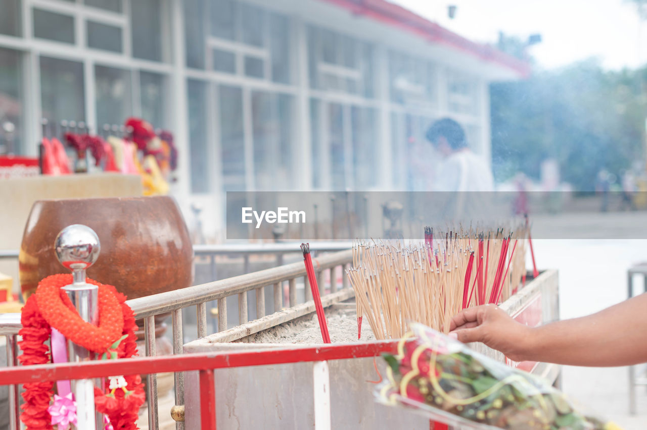 Males put incense in the pot to pay for buddhist in the temple of thailand.