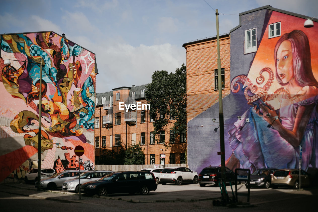 GRAFFITI ON STREET BY BUILDINGS AGAINST SKY