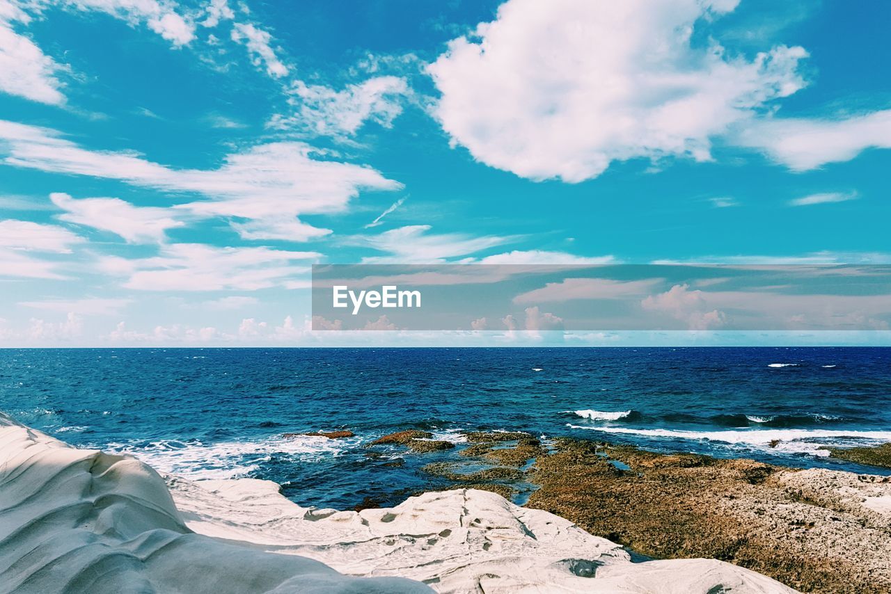 Low section of relaxing on beach against sky