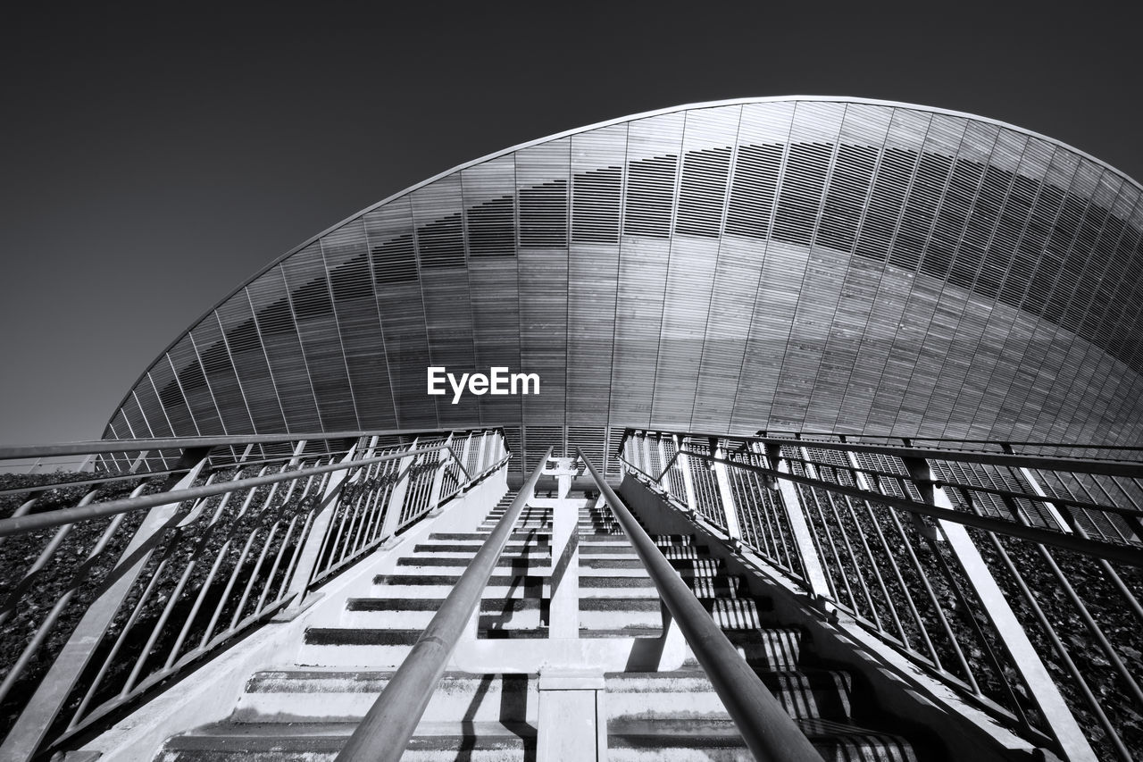 Low angle view of steps leading towards modern building against sky