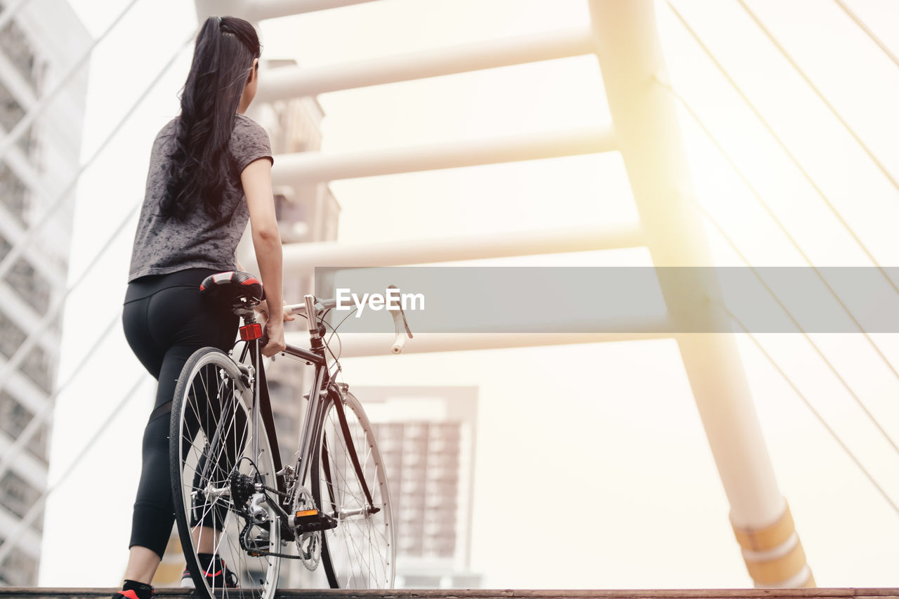 LOW SECTION OF WOMAN RIDING BICYCLE ON RAILING