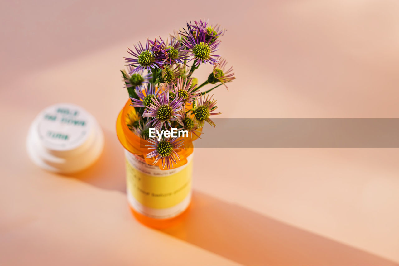 Flowers placed in the orange plastic bottle for prescribed medication. alternative medicine concept. 