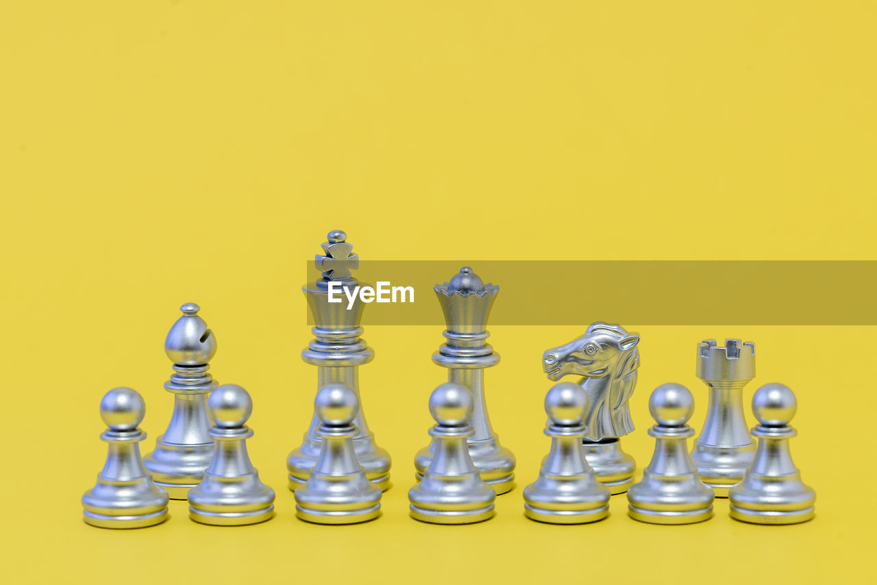 CLOSE-UP OF CHESS BOARD AGAINST COLORED BACKGROUND