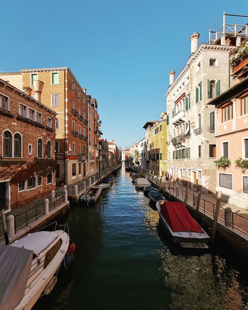 Canal amidst buildings in city against sky