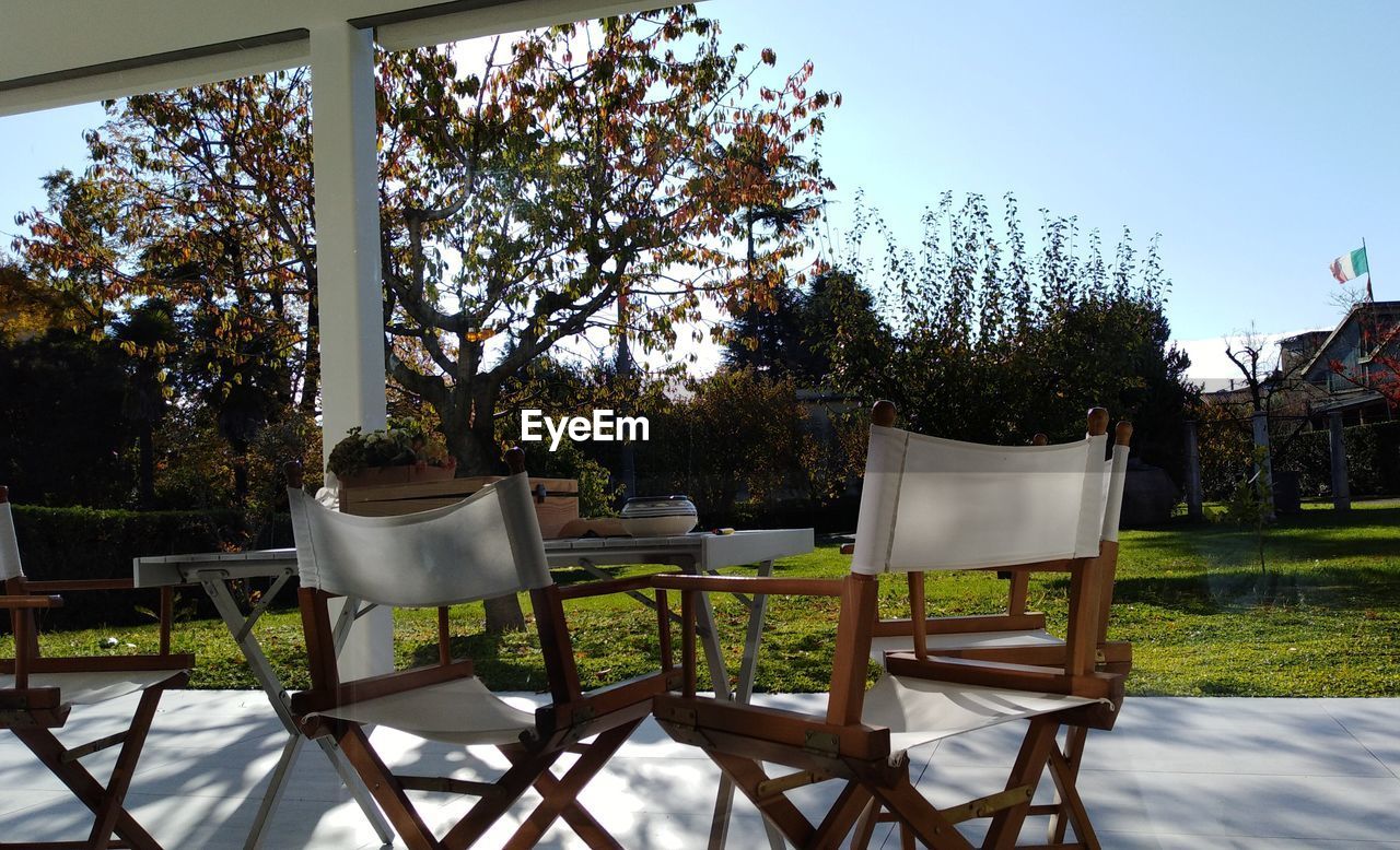 EMPTY CHAIRS AND TABLES AGAINST CLEAR SKY