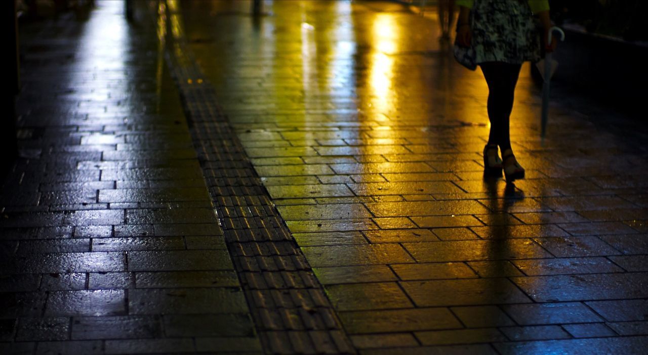 Low section of woman walking on road