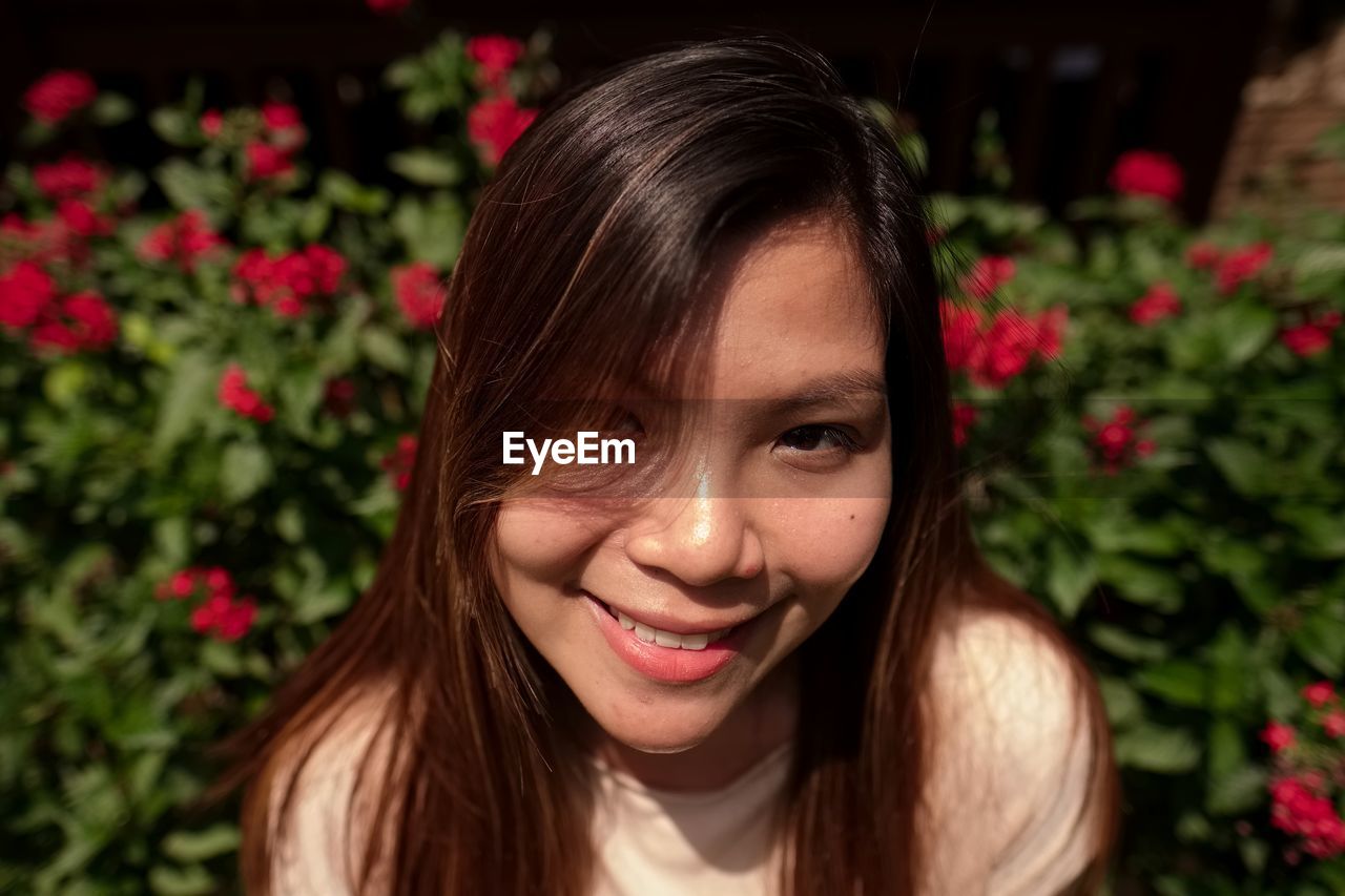 Close-up portrait of a smiling young woman in nature