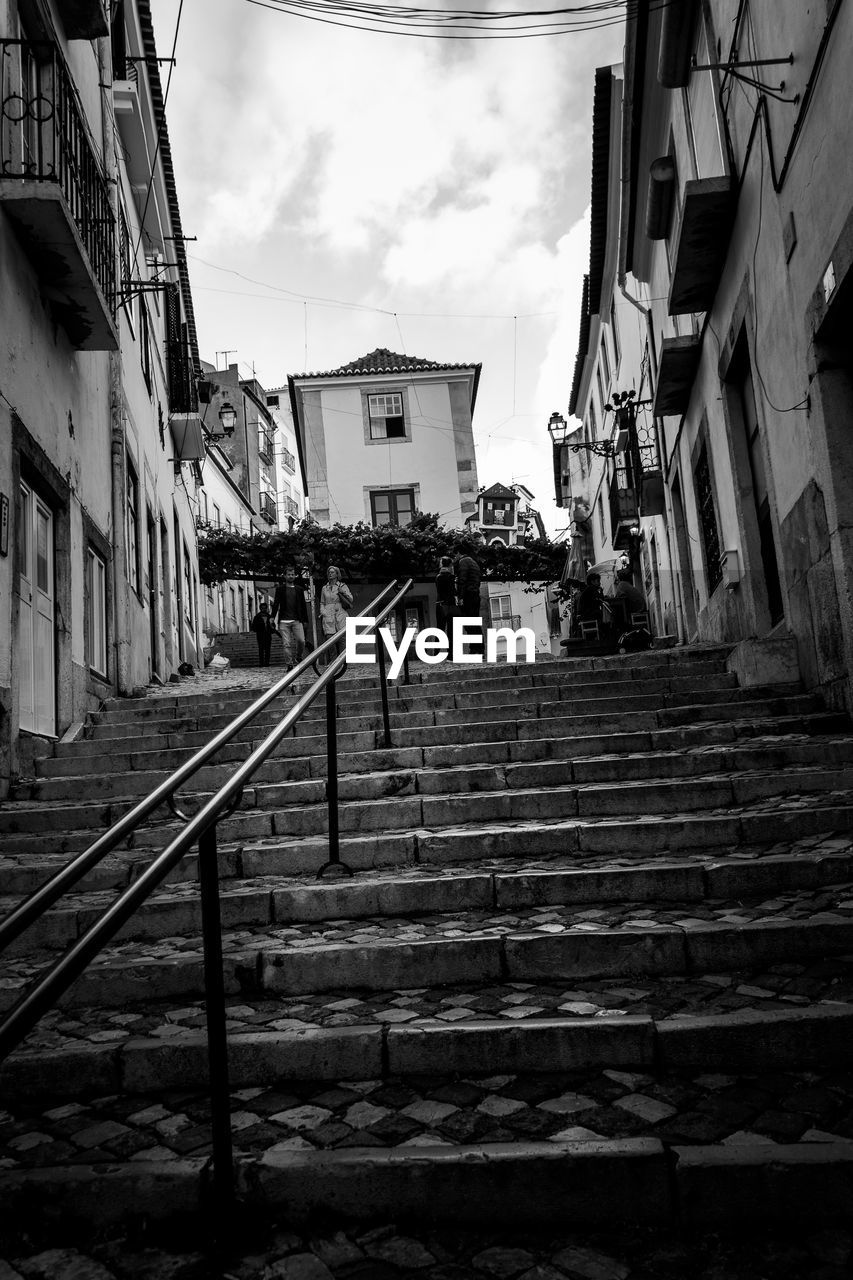 Low angle view of steps amidst buildings against sky