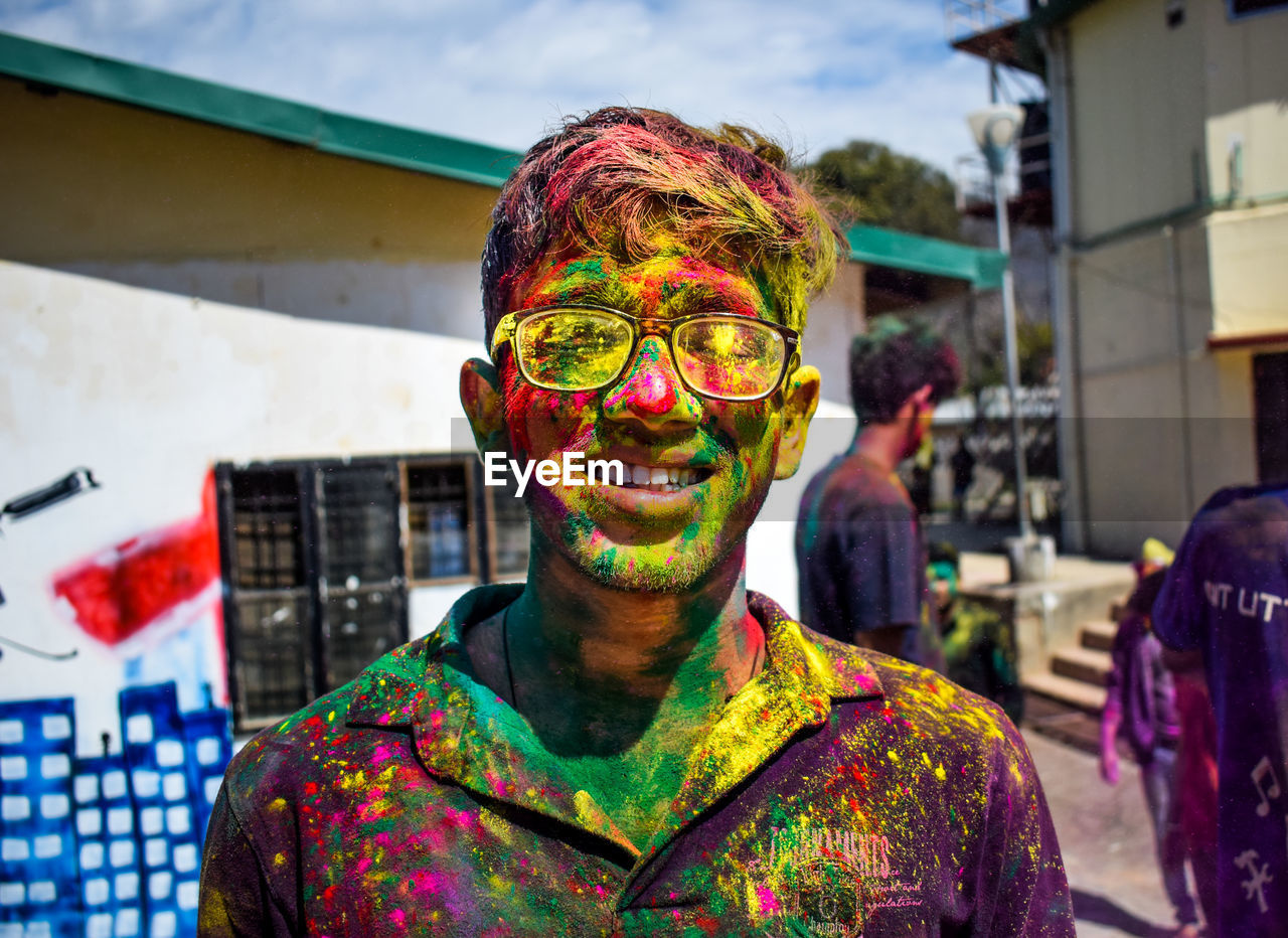 Portrait of man covered with multi colored paint